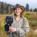 Sarah wearing a hat and holding a camera 