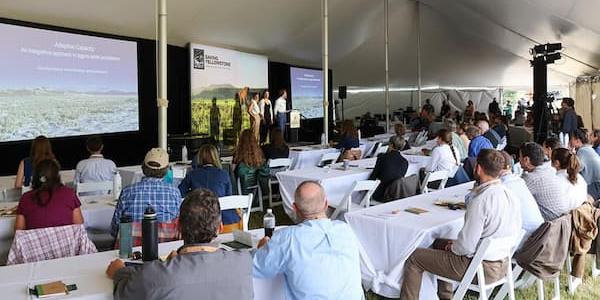People in a room listening to a speaker