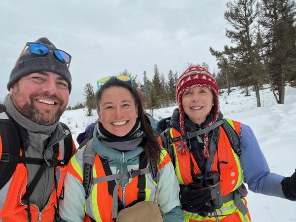Researchers Vincent Spagnuolo, Karina Li, and Dr. Diana Tomback hiking through snowy Yellowstone National Park. 