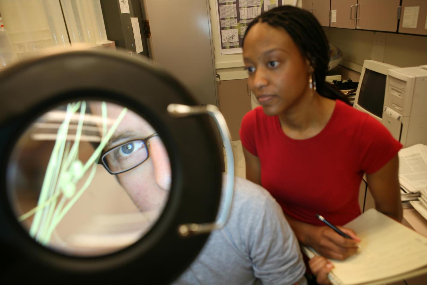 students looking through a magnifying glass