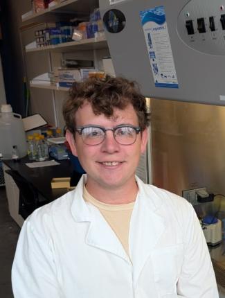Connor wearing a lab coat sitting in a lab
