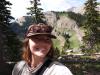 Self picture of Abby wearing a hat and sunglasses standing in the forrest