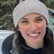Alyssa outdoors wearing a knit hat smiling at the camera