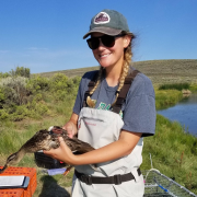 Casey near a pond holding a duck