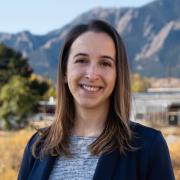 headshot of Mari standing outside near the flatirons, boulder