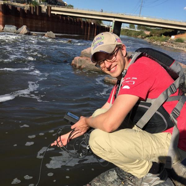 Researcher putting equipment in the water