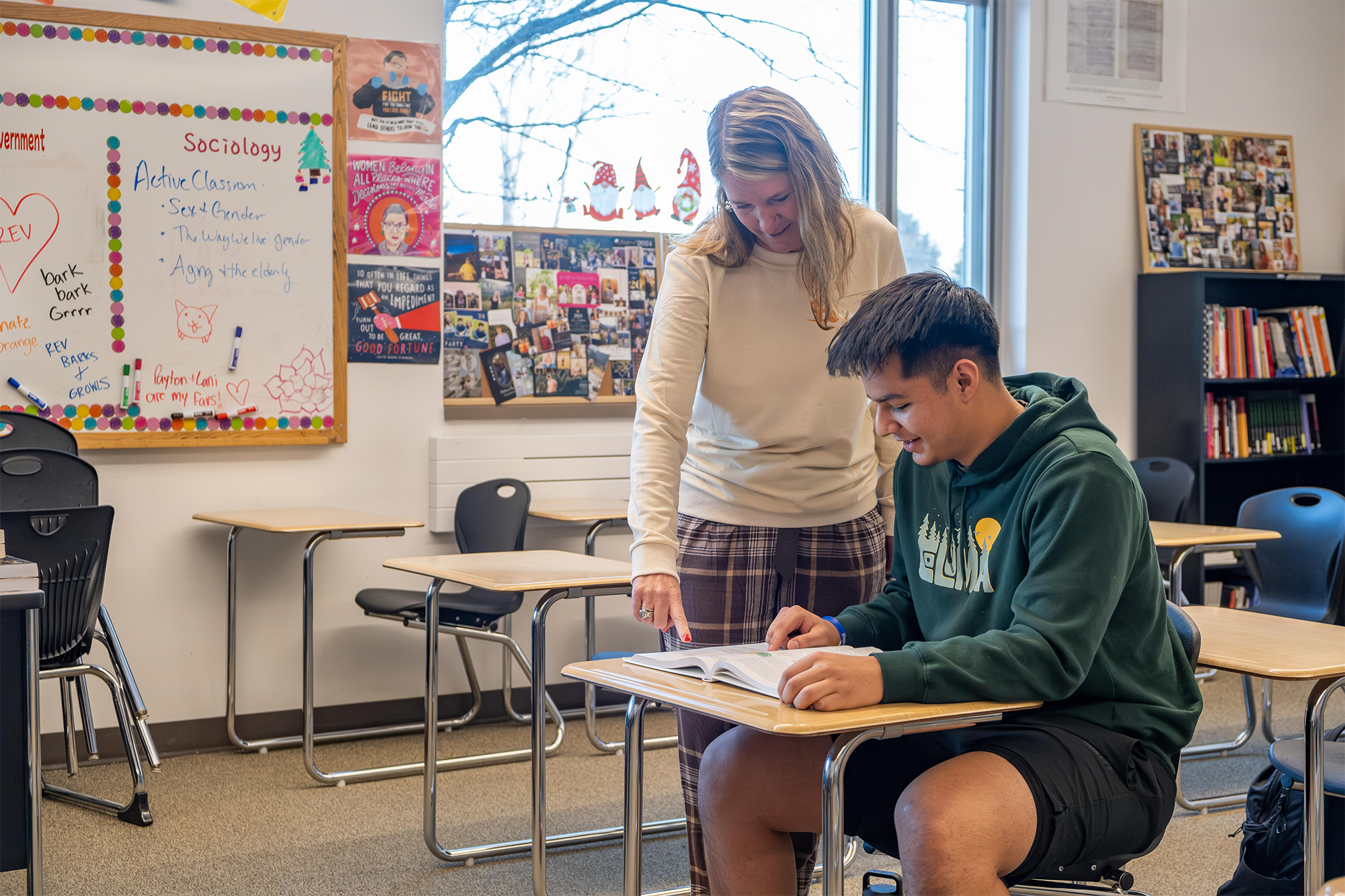 Jami and Rolando at a desk teaching