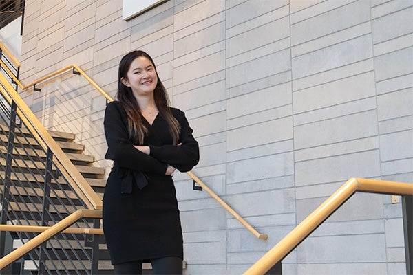 Junfei stands in front of stairs.