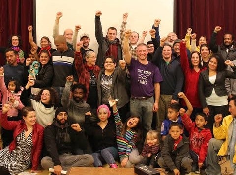 Romero Troupe actors and actresses gather with fists in air - James in middle