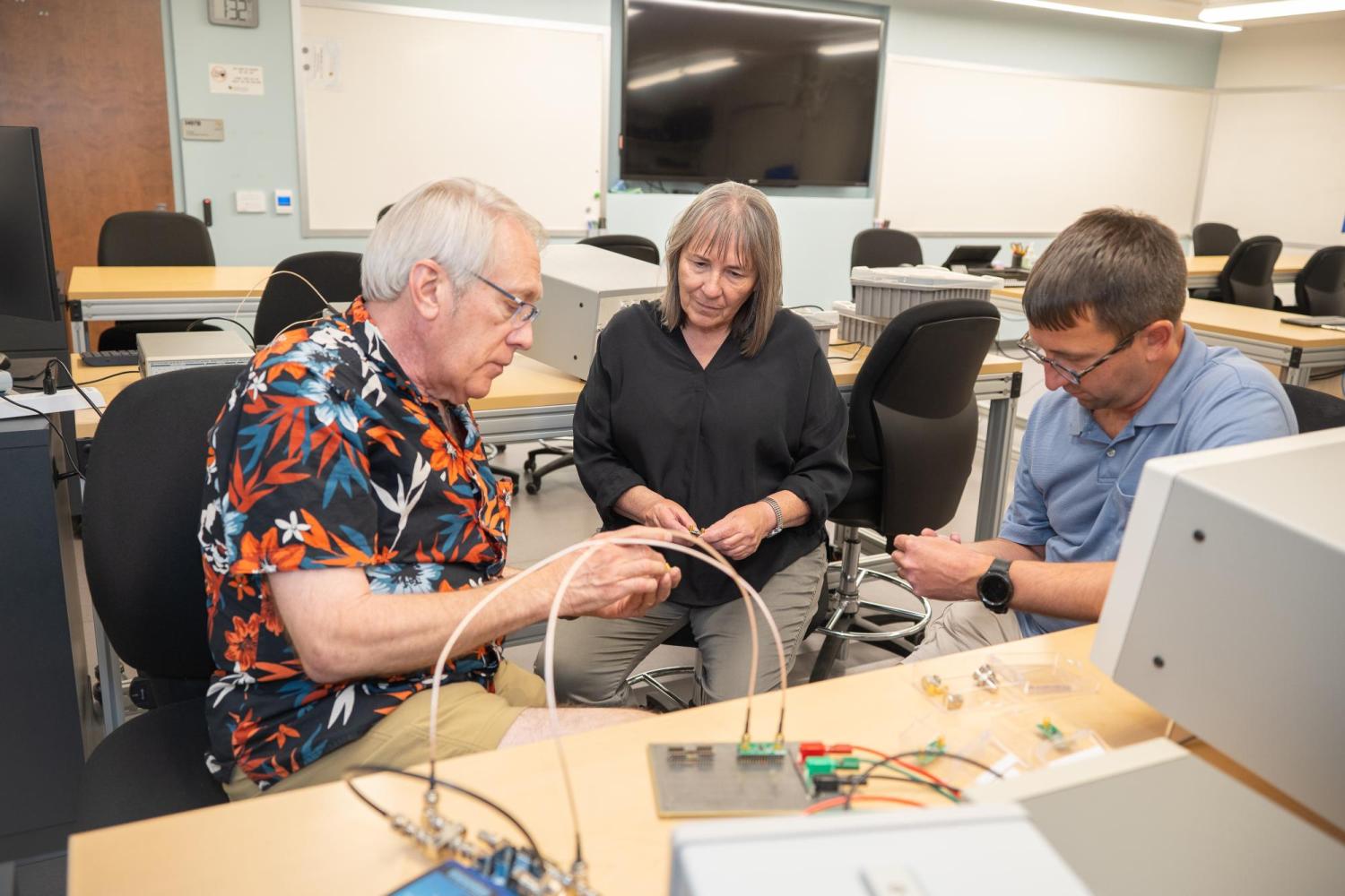 Martin, Cynthia, and Charles sit in quantum lab talking