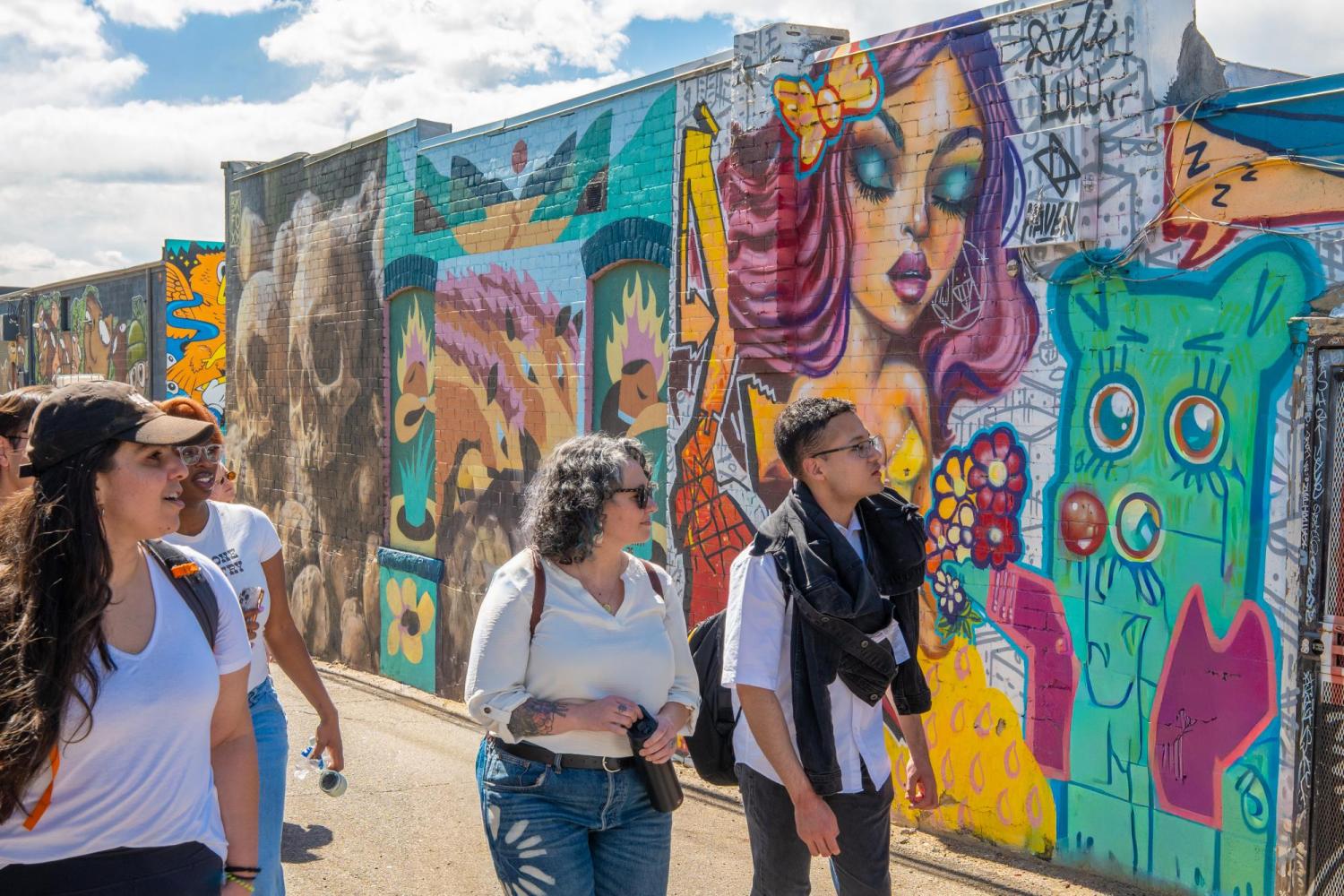 students walking down an alley in RiNo looking at street art
