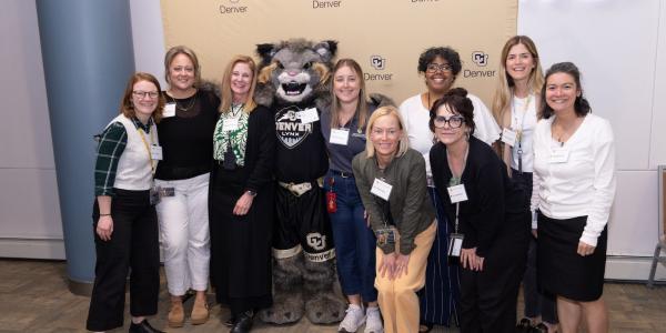 Group of staffers with CU Denver Lynx in the middle to celebrate staff accomplishments.