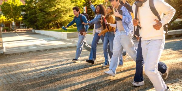 students walk together laughing on college mall