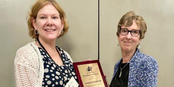 Amy holds award plaque