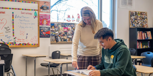 Jami and Rolando at a desk teaching