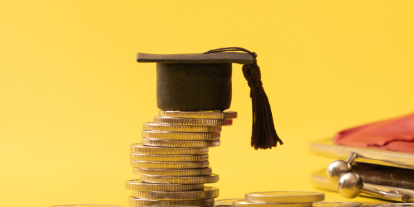 A graduation cap on top of quarters to imply the awarded grant money 
