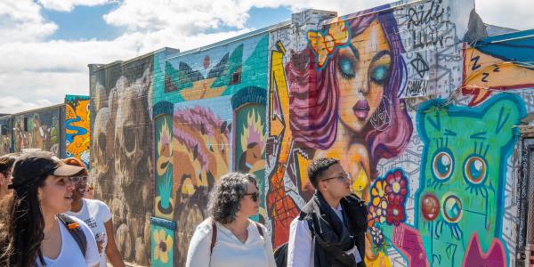 students walking down an alley in RiNo looking at street art
