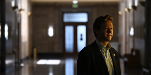 Denver Mayor Mike Johnson stands in a dark hallway