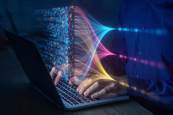 Hand on laptop keyboard with data overtop
