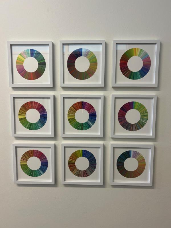This is a piece of art. There are nine square tile arranged in a 3x3 formation. Each of the nine squares as a "wheel" of color, and the colors are arranged on a different machine learning algorithm.