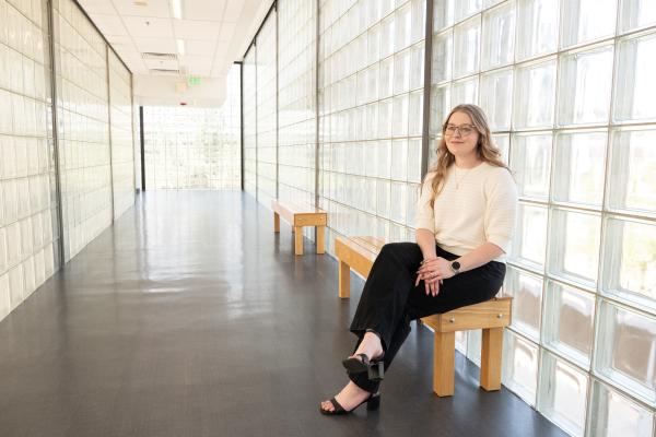 Kayley sits in glass hallway
