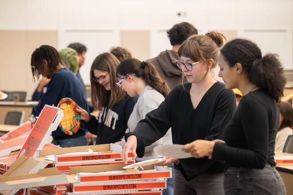 Students gather in line for pizza provided at the event