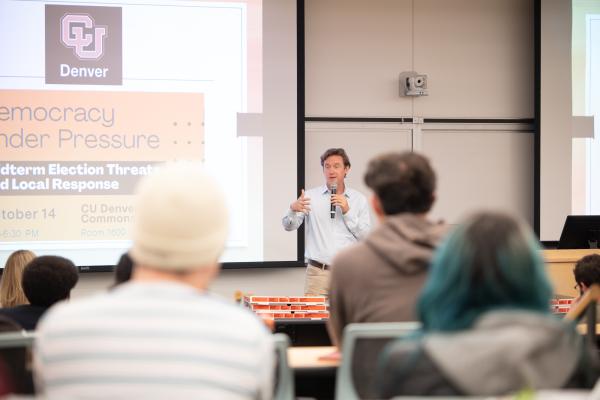 Denver Mayor Mike Johnston talks to students in classroom - medium shot