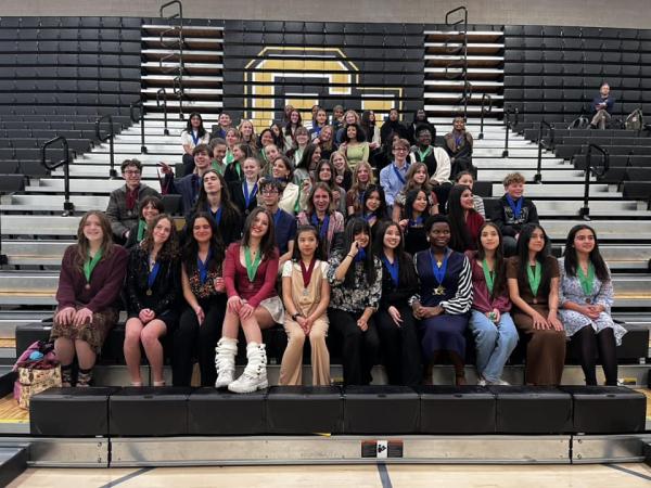 high school students sit in CU Denver gymnasium.