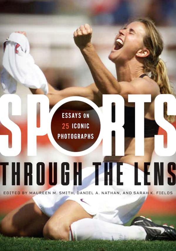 Kneeling female athlete celebrating win and clenching jersey in fist
