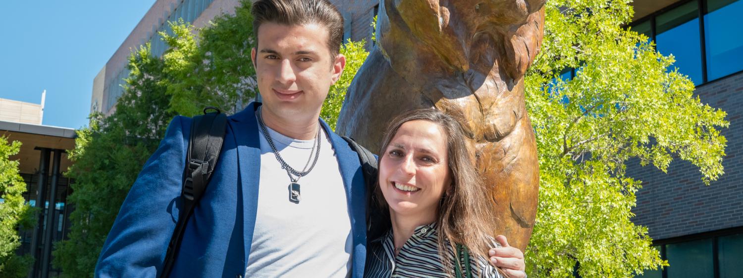 Kaya and mother stand in front of the Milo Lynx status outside