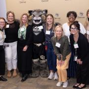 Group of staffers with CU Denver Lynx in the middle to celebrate staff accomplishments.