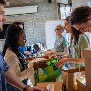 People smile while boxing up donations