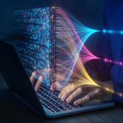 Hand on laptop keyboard with data overtop