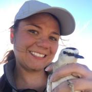 Dr. Allison Pierce holds a bird and smiles