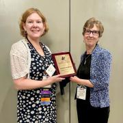 Amy holds award plaque