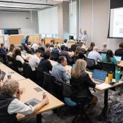 Attendees sit in CU Anschutz classroom listening to Scott Thompson