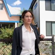 Dr. Esther Sullivan stands in front of housing