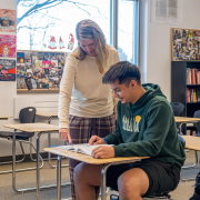 Jami and Rolando at a desk teaching