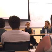 Shelby Cravens and Katie Stiffler sit at table talking to class
