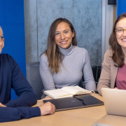 CU Denver Economics Professors Hani Mansour, Andrea Velasquez, and Chloe East sit at a table with laptop