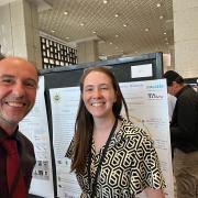 selfie taken by Langou with Hamilton on the side during poster session, we see Hamilton's poster in the background