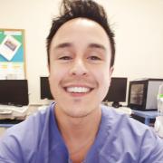 Lee Tafoya, CU Denver graduate in Psychology and Philosophy, smiles in scrubs.