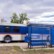 A bus zooms past a bus stop