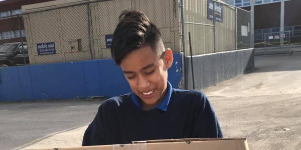 student holding box of supplies