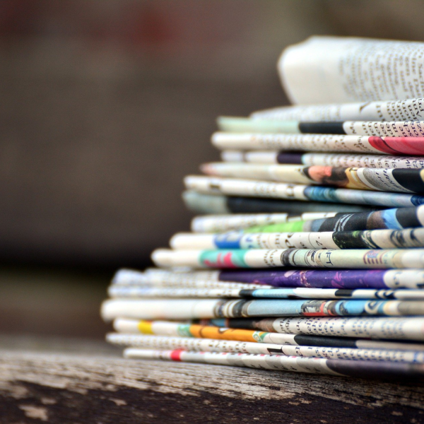 Stack of folded newspapers on wooden table