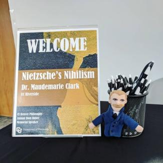 Poster for Nietzsche's Nihilism lecture and Nietzsche plush