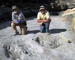 Martin Lockley (right) and Ken Cart pose beside large dinosaur scrapes in western Colorado
