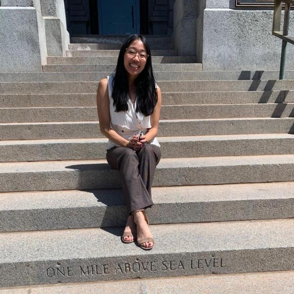 Photo of Elizabeth Low sitting on a concrete staircase outside