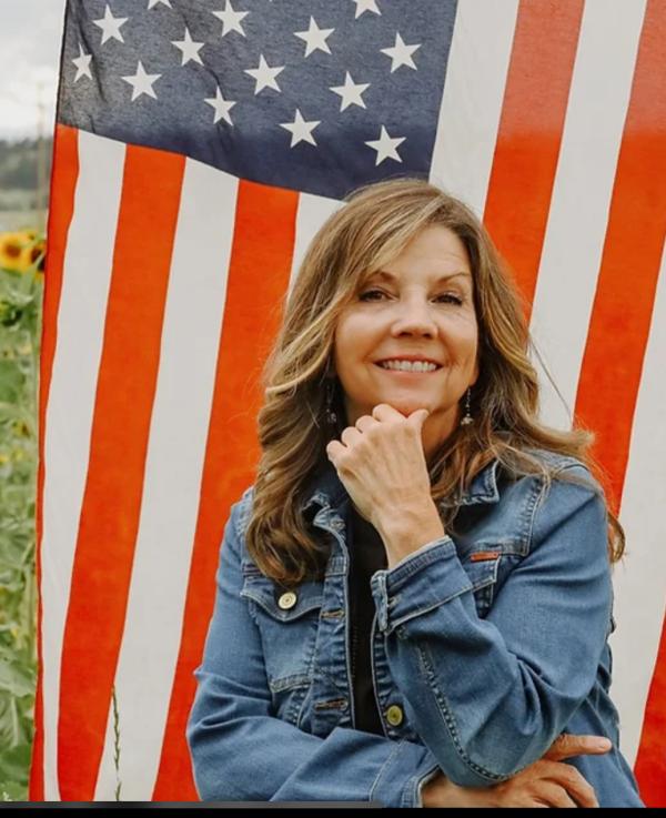 Karen Breslin in front of American flag 