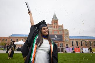 Graduating student celebrating in front of Tivoli building